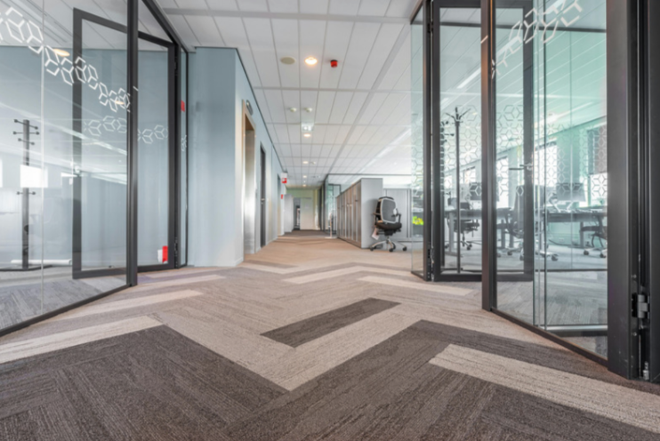 Clean commercial office hallway with glass meeting rooms